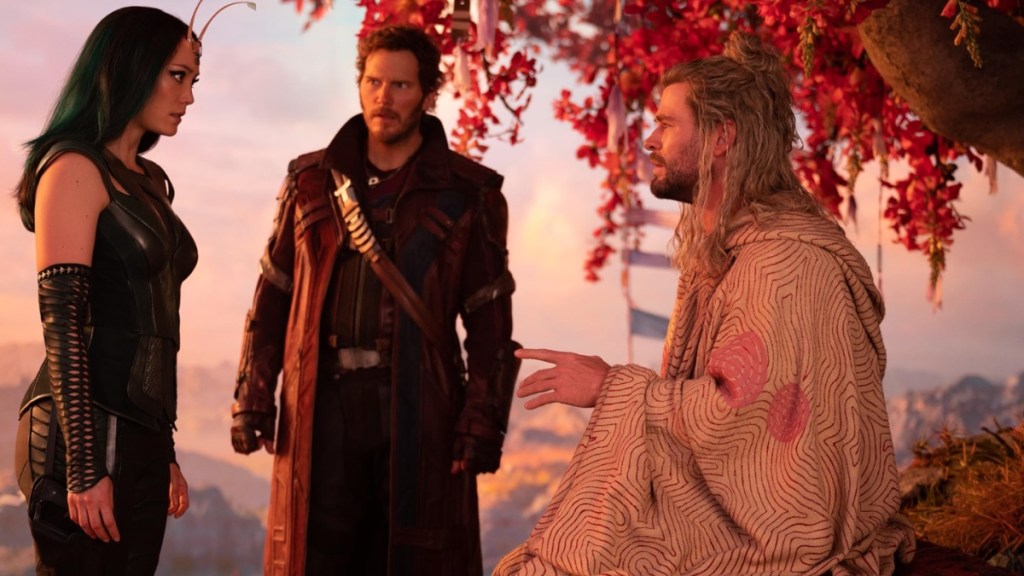 Thor sits on a rock and talks to Star Lord and Mantis.